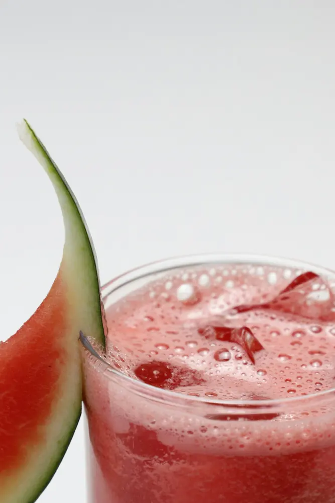 Iced watermelon juice beside a watermelon slice